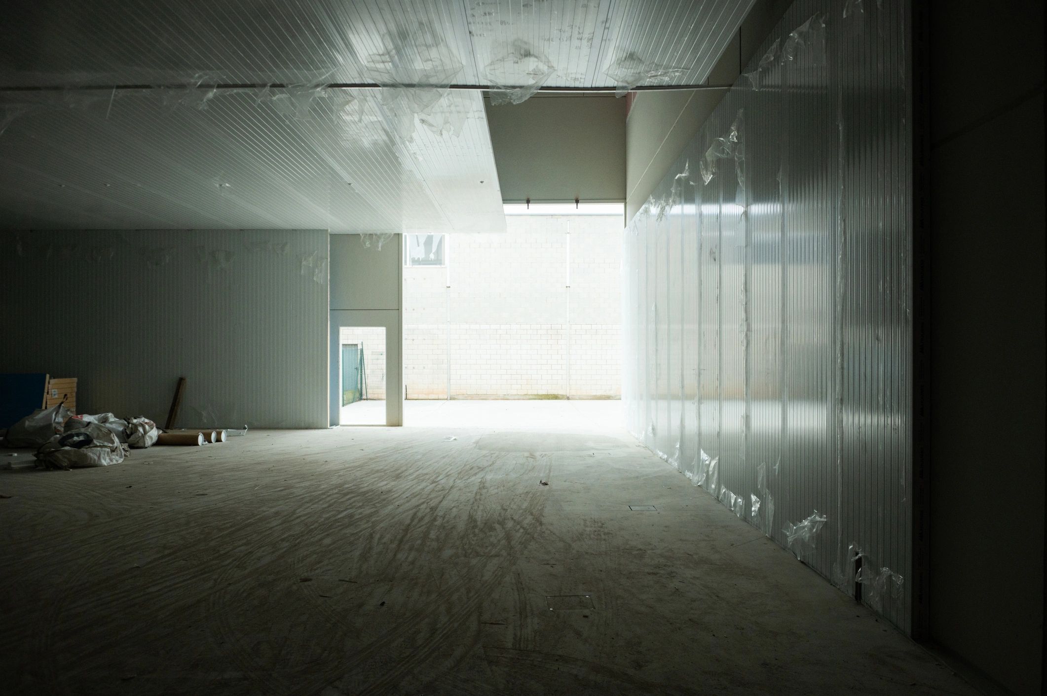 Empty warehouse interior during commercial build-out, looking toward large opening
